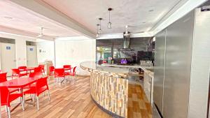a kitchen with red chairs and a bar in a room at HOTEL REAL UCUM in Ocum