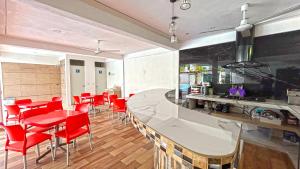 a kitchen and dining room with red chairs and a counter at HOTEL REAL UCUM in Ocum
