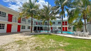 a building with palm trees and a swimming pool at HOTEL REAL UCUM in Ocum
