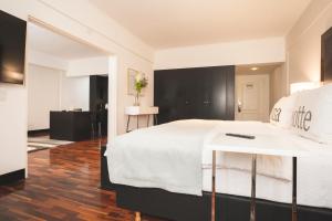 ein Schlafzimmer mit einem großen weißen Bett und schwarzen Schränken in der Unterkunft Hotel Tolosa in Puerto Madryn