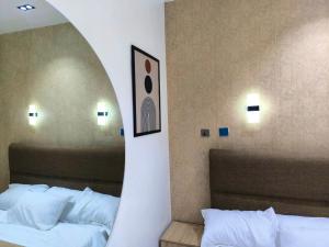 a mirror above two beds in a hotel room at Cosmo Haven Suites - Self Contained Apartment in Ibadan