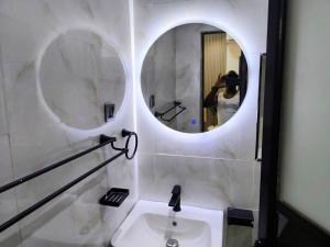 a person taking a picture of a bathroom with a mirror at Cosmo Haven Suites - Self Contained Apartment in Ibadan