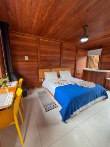 a bedroom with a bed and a wooden ceiling at Refúgio Allamanda in Visconde De Maua