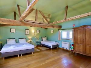 two beds in a room with green walls and wooden beams at La Tour de la Chapelle in Couthuin