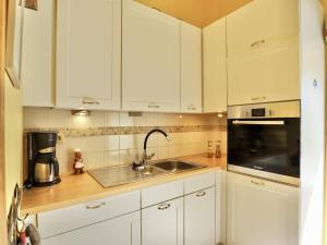 a kitchen with white cabinets and a sink at La Tour de la Chapelle in Couthuin +32 photos
