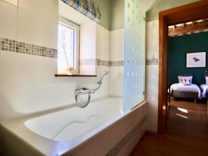 a bath tub in a bathroom with a window at La Tour de la Chapelle in Couthuin