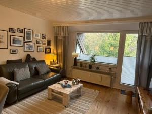 a living room with a leather couch and a window at Ferienwohnung Woodlook in Bad Sachsa