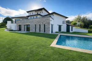 a house with a swimming pool in front of a yard at Villa ALDAKETA in Urrugne