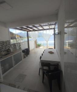 a kitchen and dining room with a table and chairs at Recanto Vista Mar - Costa Verde, Mangaratiba in Mangaratiba