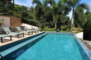 a swimming pool with chaise lounge chairs next to a resort at Pousada Villa Canaã in Búzios +112 photos