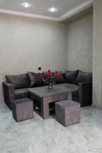 a living room with a couch and a table with flowers at Livana Guesthouse - Goris in Goris
