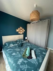 a bedroom with a bed with blue sheets and towels at Maison cosy au calme in La Colle-sur-Loup