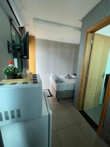 a small room with a bed and a bathroom at Studio compacto em Camboriú in Camboriú
