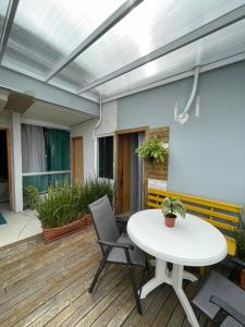 a patio with a white table and chairs at Studio compacto em Camboriú in Camboriú +4 photos