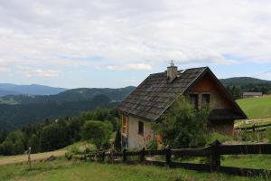 an old house on a hill with a fence at Domek u Johnnego 28 in Piwniczna Zdrój
