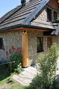 a stone house with a gambrel roof and a patio at Domek u Johnnego 28 in Piwniczna Zdrój +11 photos