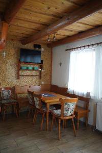a dining room with a wooden table and chairs at Domek u Johnnego 28 in Piwniczna Zdrój