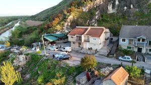a house with cars parked in a parking lot next to a mountain at Luxury House Petrovic - Vranjina Skadar Lake in Podgorica