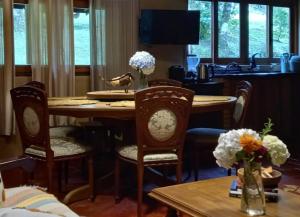a dining room with a table and chairs with flowers at Rio Privativo, Piscina e Starlink - Casa Terras de Minas in Gonçalves