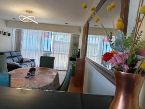 a living room with a table with a vase of flowers at villa hermosa cayma in Yanahuara