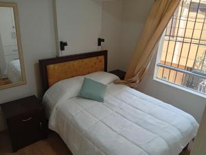 a bedroom with a bed with a blue pillow on it at villa hermosa cayma in Yanahuara