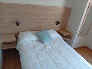 a bedroom with a white bed with a wooden headboard at villa hermosa cayma in Yanahuara +1 photo