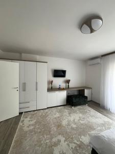 a living room with white cabinets and a television at Apartmani Zeleni Horizont in Bratunac