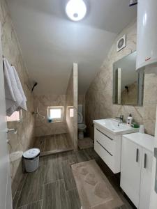 a bathroom with a sink toilet and a shower at Apartmani Zeleni Horizont in Bratunac +16 photos