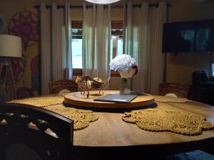 a dining room table with a vase of flowers on it at Rio Privativo, Piscina e Starlink - Casa Terras de Minas in Gonçalves +93 photos