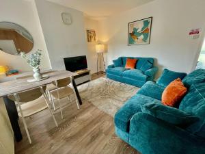 a living room with a blue couch and a table at Petal House, Gloucester - Large, Spacious and charming in Gloucestershire