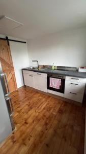 a kitchen with a sink and a wooden floor at Mehrere Zimmer in erster Lage in Siegen