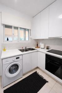 a white kitchen with a washing machine and a sink at Rhodes Nest in Ixia +13 photos