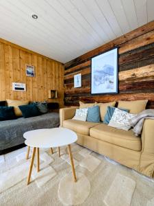 a living room with a couch and a table at Le refuge de Marius - logement de colpoteur in Albiez-Montrond