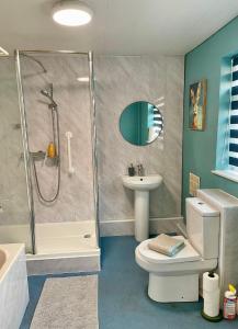 a bathroom with a shower and a toilet and a sink at Petal House, Gloucester - Large, Spacious and charming in Gloucestershire +21 photos
