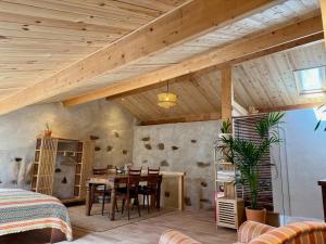 a room with a wooden ceiling with a table and chairs at Wellbeing guesthouse Casa é Connosco in Alvaiázere