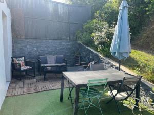 a patio with a table and an umbrella and chairs at Maison cosy au calme in La Colle-sur-Loup