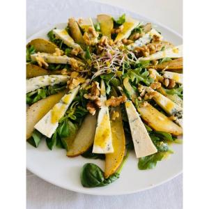 a white plate with a salad with bananas and nuts at Hotel pod Dębem in Szydłowiec