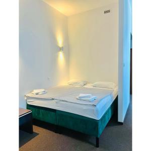 a bed in a room with two towels on it at Hotel pod Dębem in Szydłowiec