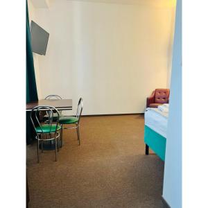 a room with a bed and a table and chairs at Hotel pod Dębem in Szydłowiec