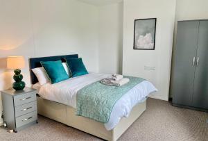 a bedroom with a bed with blue pillows at Petal House, Gloucester - Large, Spacious and charming in Gloucestershire