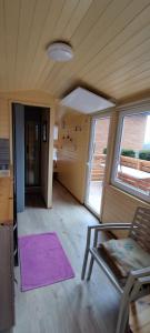 a living room with a purple rug and a chair at Tiny house Horní Planá in Horní Planá
