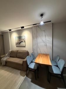 a living room with a couch and a table and chairs at Casa Del Sol - Shengjin in Shëngjin +3 photos