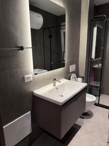 a bathroom with a sink and a toilet and a mirror at Casa Del Sol - Shengjin in Shëngjin