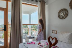 a woman standing in a bedroom looking out the window at Lagoon Villa Maldives in Thoddoo