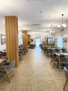 a restaurant with tables and chairs in a room at Clean City Agrotourism in Durrës
