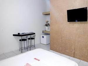 a room with a table and a tv on a wall at Hotel Planalto 2 in Governador Valadares