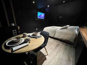 a room with a table and a bed and a television at Fleur de Lune in Amiens
