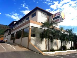 un edificio de hotel con palmeras delante en Hotel Planalto 2, en Governador Valadares