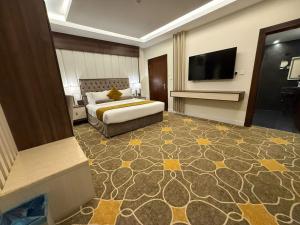 a hotel room with a bed and a flat screen tv at Garden Melenium - Jazan in Jazan