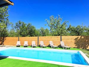 a group of chairs sitting next to a swimming pool at Apartments Villa Mavi Plitvice in Drežnik Grad